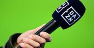 m_30616216-die-hand-eines-reporters-haelt-bei-einem-interview-vor-dem-spiel-ein-mikrofon-mit-d...jpg